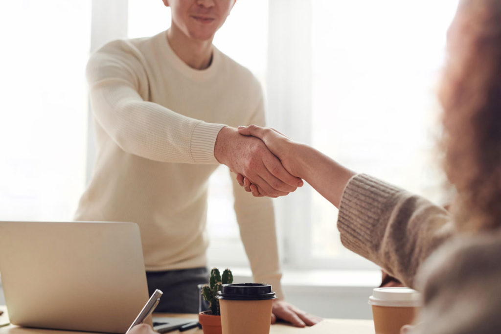 candidate shaking interviewers hand in competency based interview